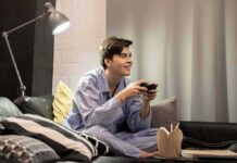 Worker Shortage TIMEBOMB — Where Did Men Go? Teen in pajamas playing video games on a couch