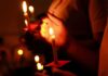 Balkan Defiance Explodes — Courts Challenged Hands holding lit candles in a dark setting