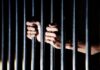 hands gripping prison bars