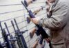 Person examining a black rifle in a gun store