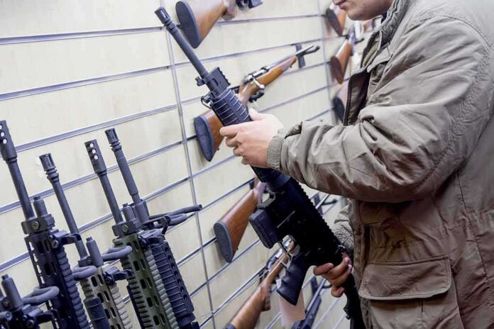 shutterstock_1181974606 Person examining a black rifle in a gun store