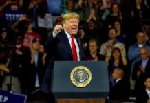 man speaking at a podium during a rally
