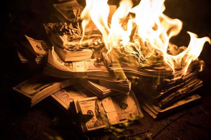 Stacks of U.S. dollar bills burning in bright flames
