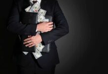 Debt ‘Heart Attack’ Warning Rocks Washington Businessman hugging briefcase stuffed with cash