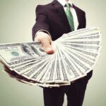 Legal Vote-Buying Rocks California Businessperson holding a fan of US dollar bills
