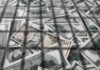 DOJ Blitz Nails 455 In Health Scams pile of us dollar bills with a ten-dollar note on top