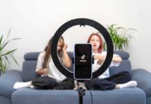 Paid Posts Exposed — Sacramento Sharpens the Knife smartphone on ring light filming two people on a couch