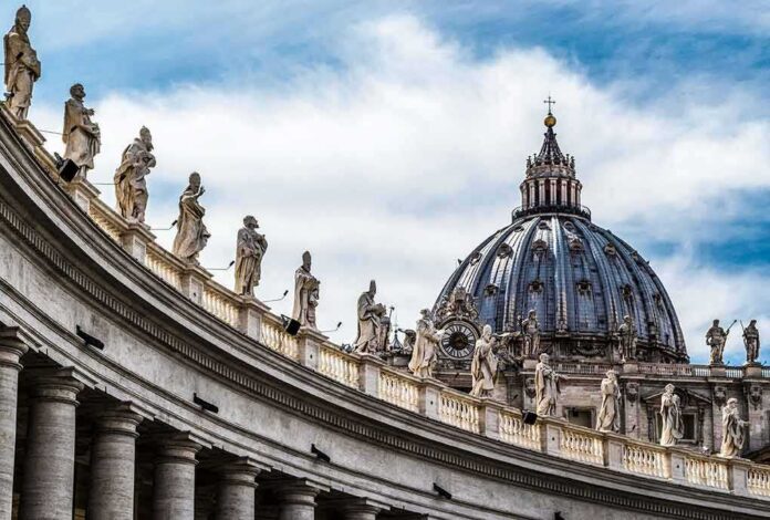 shutterstock_368201633-1 St. Peter's Basilica dome with statues along colonnade