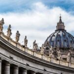 Communist Grip Alleged — Bishops Caught In Middle St. Peter's Basilica dome with statues along colonnade
