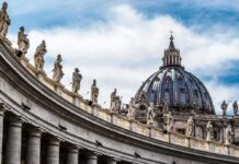 St. Peter's Basilica dome with statues along colonnade