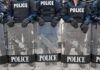 Cops Caught Snooping—Audit Blows It Up Police officers in riot gear holding shields