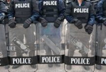 Police officers in riot gear holding shields