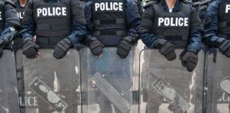 Police officers in riot gear holding shields