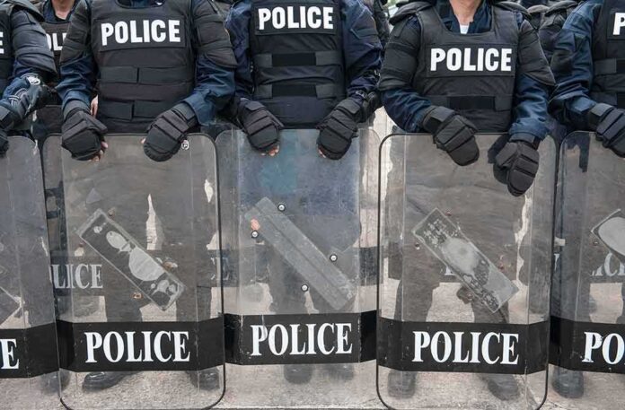 Police officers in riot gear holding shields