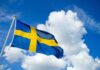 Sweden Nails Covert Kremlin Meddling Sweden flag waving against a blue sky with clouds