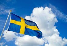 Sweden Nails Covert Kremlin Meddling Sweden flag waving against a blue sky with clouds