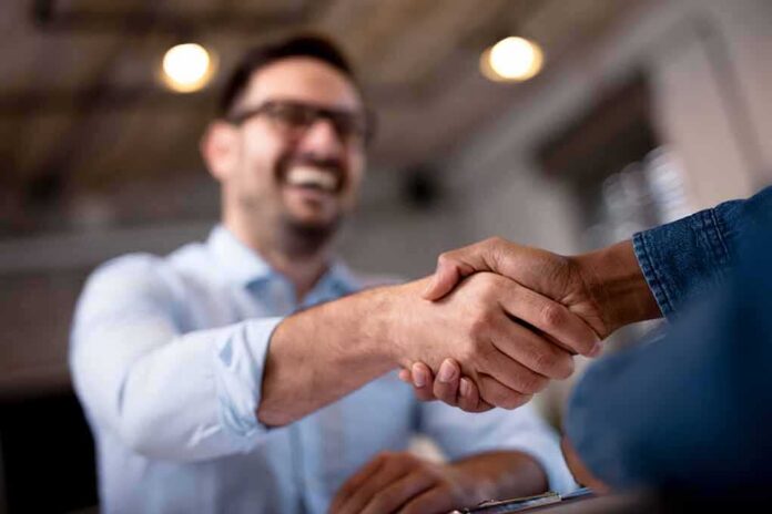 Two people shaking hands in an office