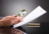 Records Faked After Audit — Taxpayers Exposed Hands holding magnifying glass over contract document