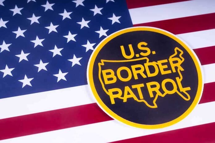 shutterstock_1051372520 U.S. Border Patrol emblem on American flag