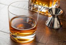 Tariff Gone – Whiskey Math Changes Overnight Whiskey in a rocks glass on a wooden table