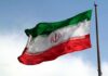 Iran Dares Trump: Open Strait – On Our Terms Iranian flag waving on a pole