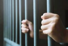 hands gripping prison bars