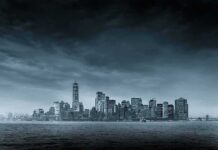 city skyline across water under overcast sky