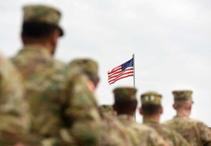 shutterstock_1170998920-1 U.S. flag flying above a formation of soldiers in uniform