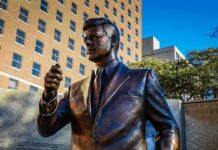 Memorial Unveiled – Free Speech Flashpoint Erupts In Midtown Bronze statue of a suited man in a city plaza