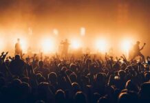 Concert Flag Sparks Singapore Ban Rock band performing on stage with bright backlights and cheering crowd