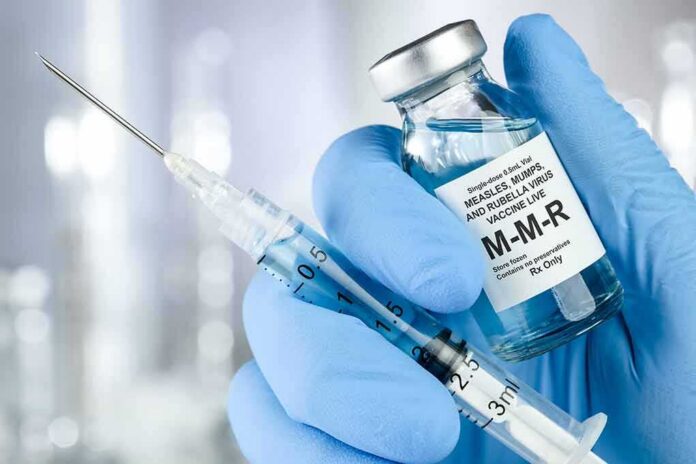 shutterstock_1449408860-1 Gloved hands holding a vaccine vial and syringe