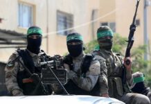 armed masked men in camouflage with green headbands