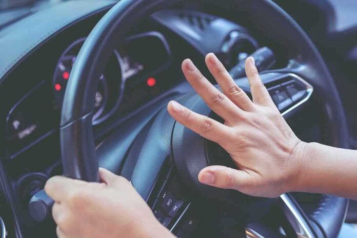 shutterstock_1730807383 Driver pressing car horn on steering wheel