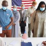 ‘Human Error’ Stalls 28,000 Votes Voters wearing masks stand in line at a polling station