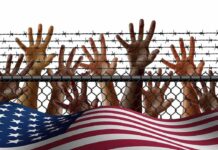 Race-Based Refugee Gambit Ignites Firestorm Hands reaching through a chain-link fence topped with barbed wire