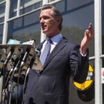 Government Off Button? California Moves Gavin Newsom speaks at a press conference with microphones outside a building