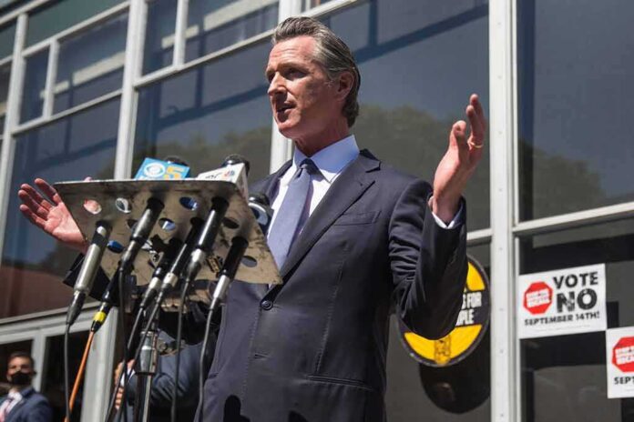 shutterstock_2041539359 Gavin Newsom speaks at a press conference with microphones outside a building