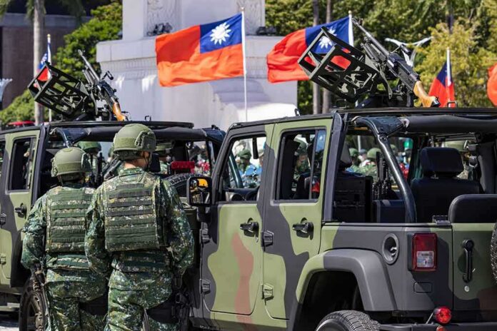shutterstock_2056330949 Soldiers beside camouflaged military vehicles with mounted guns and flags