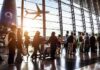 Flights Axed: UAE Grounds Iranian Jets – Instantly Passengers queue inside an airport terminal at sunset