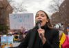 AOC’s Brand Backfires – Branded Toxic In Swing Seats woman speaking into a microphone at an outdoor protest