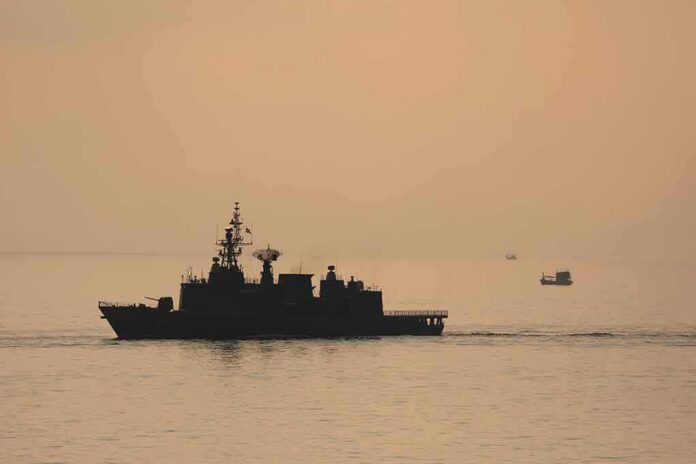 shutterstock_2187790935 naval ship silhouette at sea during sunset