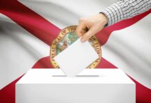 Hand casting a ballot in front of the Florida state flag