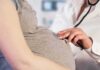 Pregnant woman examined with stethoscope