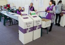 Dorota Kędzierzawska at a polling place with ballot boxes and election staff