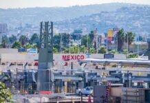 State Agency Dumps Teen At Border? Border crossing booths at Mexico entry point with cityscape in background