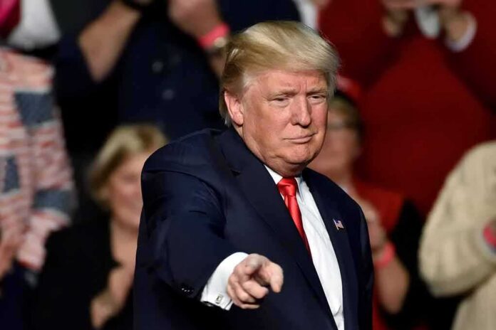shutterstock_1083789467 Donald Trump points toward the audience at an event