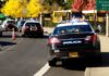 Mayor Sued By Her Police Chief Police cars with lights on near school buses on a city street