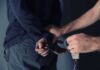 Porch Ambush Sparks 76-Count Bombshell person being handcuffed behind the back