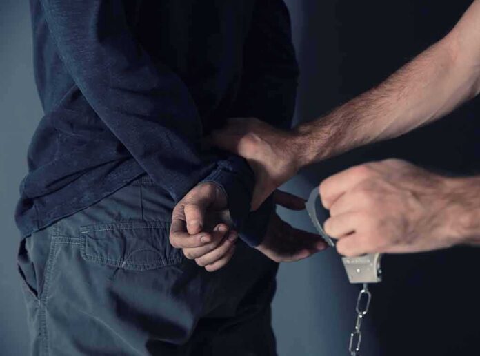 shutterstock_1267222249 person being handcuffed behind the back