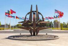 Kaliningrad Radar Puts NATO On Notice Metal sculpture with surrounding national flags in a plaza